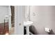 Half bathroom with pedestal sink, brushed nickel hardware, grey walls and tile flooring at 10941 Pendragon Pl, Raleigh, NC 27614