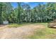 Backyard featuring a gravel lot, storage shed and a grassy lot with trees at 1118 Oakridge Duncan Rd, Fuquay Varina, NC 27526