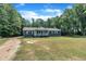 Inviting home with a covered porch and a wide front lawn edged by dense, shady trees at 1118 Oakridge Duncan Rd, Fuquay Varina, NC 27526