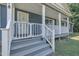 A welcoming front porch with white railings leads to a front door with an 'S' wreath at 1118 Oakridge Duncan Rd, Fuquay Varina, NC 27526