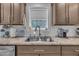 Stainless steel kitchen sink with modern faucet, marble countertops, and tile backsplash at 1118 Oakridge Duncan Rd, Fuquay Varina, NC 27526