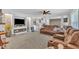 Open-concept living space featuring plush, reclining furniture, a stone-accented wall, and a ceiling fan at 1118 Oakridge Duncan Rd, Fuquay Varina, NC 27526