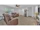 A cozy living room featuring reclining sofas, neutral carpeting, and natural light from the windows at 1118 Oakridge Duncan Rd, Fuquay Varina, NC 27526