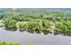 Aerial view of a river winding through a wooded area with scattered homes at 1164 Keith Hills Rd, Lillington, NC 27546