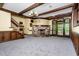 Open basement area features a stone fireplace, wooden beams, carpeting, and access to the outdoors at 1164 Keith Hills Rd, Lillington, NC 27546