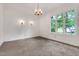 Spacious bedroom featuring plush carpeting, natural light, and elegant sconce lighting at 1164 Keith Hills Rd, Lillington, NC 27546