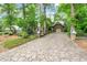 Long, patterned stone driveway leading to a Tudor-style home with a garage at 1164 Keith Hills Rd, Lillington, NC 27546