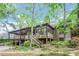 Stunning home featuring multi-level decks, lush greenery, and charming architectural details at 1164 Keith Hills Rd, Lillington, NC 27546
