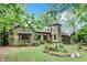 Charming Tudor-style home featuring a unique stone tower and lush landscaping at 1164 Keith Hills Rd, Lillington, NC 27546