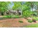 Tudor-style home with stone accents, mature trees, and manicured landscaping at 1164 Keith Hills Rd, Lillington, NC 27546