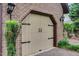 A tan garage door with black hardware complements the brick facade and landscaping of the house at 1164 Keith Hills Rd, Lillington, NC 27546