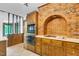 Rustic kitchen with brick oven-like facade and classic wood cabinets at 1164 Keith Hills Rd, Lillington, NC 27546