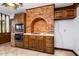 Vintage kitchen with an arched brick cooking area and wood cabinetry at 1164 Keith Hills Rd, Lillington, NC 27546