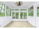 Bright sunroom surrounded by windows with views of a gazebo and lush green trees at 1164 Keith Hills Rd, Lillington, NC 27546