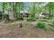 Lush backyard with mature trees, landscaping, swing, and charming gazebo at 1164 Keith Hills Rd, Lillington, NC 27546