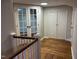 Upstairs hallway featuring hardwood floors, wood railing, and glass doors at 119 W Vernon Ave, Wake Forest, NC 27587