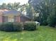 Mature bushes line the brick home exterior leading to large back yard and storage shed at 143 Cedarwood Dr, Henderson, NC 27536