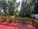 Spacious backyard featuring a stained wooden deck and a storage shed among mature trees at 143 Cedarwood Dr, Henderson, NC 27536