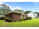 Side view of the all brick home showcases green lawn, white trim, and a red wooden deck at 143 Cedarwood Dr, Henderson, NC 27536