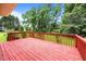 View from the home's expansive red wooden deck looking out to spacious back yard and treeline at 143 Cedarwood Dr, Henderson, NC 27536