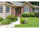 All brick home's front is lined with sculpted bushes and a walkway leading up to the glass-paned front door at 143 Cedarwood Dr, Henderson, NC 27536