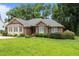 All brick home with manicured lawn, lush bushes, and well-maintained green shutters add charm to this lovely house at 143 Cedarwood Dr, Henderson, NC 27536