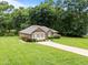 Well-maintained brick home with a lush green lawn and tidy landscaping at 143 Cedarwood Dr, Henderson, NC 27536