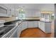 Traditional kitchen features white cabinetry, black countertops, wood floors, and stainless steel appliances at 143 Cedarwood Dr, Henderson, NC 27536
