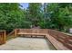 Inviting wooden back deck with built-in seating amidst lush greenery, perfect for outdoor enjoyment at 1500 Prisma Ct, Raleigh, NC 27612
