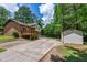Backyard featuring a detached garage, back deck, concrete driveway, and chain link fence at 1500 Prisma Ct, Raleigh, NC 27612