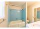 Bathroom featuring a tub with blue tile surround, a toilet, and a sink at 1500 Prisma Ct, Raleigh, NC 27612