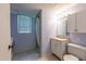 Bathroom with vanity, tiled shower, and a window providing natural light at 1500 Prisma Ct, Raleigh, NC 27612