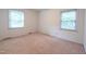 Bedroom with neutral carpet, two windows, and baseboard heating at 1500 Prisma Ct, Raleigh, NC 27612