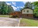 Back exterior of brick home featuring a wood deck, and fenced yard surrounded by trees at 1500 Prisma Ct, Raleigh, NC 27612