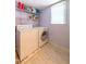 Functional laundry room with washer, dryer, shelving, and natural light from window at 1500 Prisma Ct, Raleigh, NC 27612