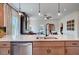 Bright kitchen with a central island, stainless steel dishwasher, granite countertops, and access to the living area at 157 Mildred Pl, Broadway, NC 27505