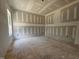 Well-lit living room with drywall, unfinished floors, and a large window at 157 Mildred Pl, Broadway, NC 27505