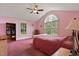 Bright bedroom featuring a ceiling fan, arched window, and hardwood floors at 180 Normandy Rd, Louisburg, NC 27549