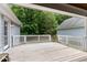 Wide angle view of back deck with white railing, wooden floor, and mature trees beyond, ready for outdoor enjoyment at 180 Normandy Rd, Louisburg, NC 27549
