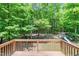 Backyard view from the deck with a playground set nestled amongst mature trees at 1826 Fillmore Dr, Creedmoor, NC 27522