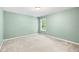 Cozy bedroom featuring green walls, a window with backyard views, and plush carpeting at 1826 Fillmore Dr, Creedmoor, NC 27522
