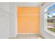Spacious walk-in closet with white wire shelving and an orange accent wall, offering ample storage solutions at 1826 Fillmore Dr, Creedmoor, NC 27522