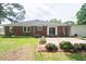 Brick home featuring a patio, lush green lawn, and beautiful landscaping, perfect for outdoor enjoyment at 205 N Augusta Ave, Benson, NC 27504