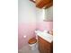Retro bathroom featuring pink tile, wood vanity, and vintage fixtures, offering a unique charm at 205 N Augusta Ave, Benson, NC 27504
