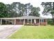 Charming brick home with mature trees and a well-maintained lawn, enhancing curb appeal at 205 N Augusta Ave, Benson, NC 27504