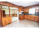Cozy kitchen featuring wood cabinetry, a green countertop, and vintage charm, seamlessly flowing into the dining area at 205 N Augusta Ave, Benson, NC 27504