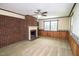 Cozy living room showcasing a classic brick fireplace and a ceiling fan at 205 N Augusta Ave, Benson, NC 27504