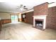 Warm living room features a brick fireplace and sliding door access to the outdoors at 205 N Augusta Ave, Benson, NC 27504