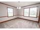 Bright living room featuring soft carpeting, large windows, and modern lighting at 205 N Augusta Ave, Benson, NC 27504