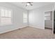 Spacious bedroom with neutral carpet, a ceiling fan, two large windows, and bright white walls at 208 Jones Hill Rd, Holly Springs, NC 27540